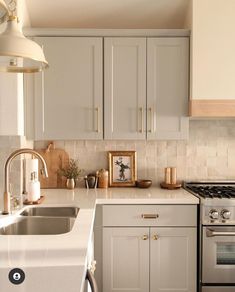 a kitchen with white cabinets and silver appliances