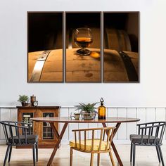 three wine glasses sitting on top of a wooden table next to a bottle and barrel