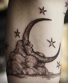 a black and white image of a crescent moon with stars on it's side