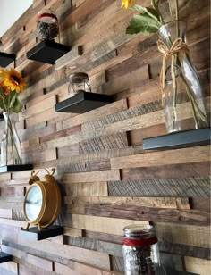 some shelves with vases and flowers on them against a wooden wall that has been made out of pallets