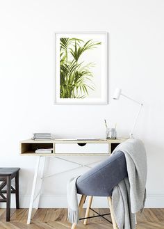 a chair with a blanket on it in front of a white wall and wooden floor