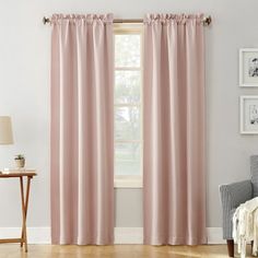 a living room with pink curtains and a chair