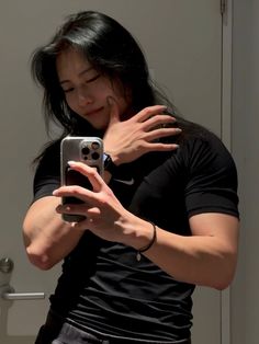 a woman is taking a selfie in the mirror with her cell phone while wearing a black shirt