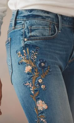 the jeans are embroidered with flowers on them