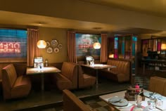 an empty restaurant with tables and chairs in front of the window, along with other dining room furniture