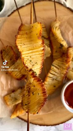 grilled pineapple skewers with ketchup and dipping sauce on the side