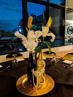 there is a vase with flowers in it on top of a gold plated table