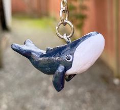 a blue and white whale toy hanging from a chain