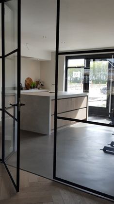 an empty room with sliding glass doors leading into the kitchen