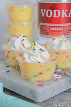 three cupcakes with white frosting and sprinkles on a tray