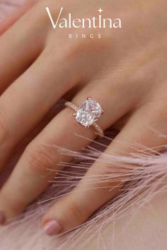 a woman's hand with a diamond ring on her finger and the words valentina rings above it