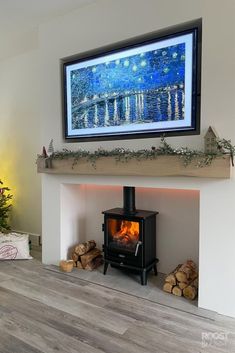 a fire place in a living room next to a painting on the wall above it