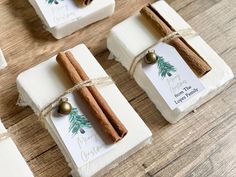 cinnamon sticks wrapped in paper and tied with twine on top of wooden table next to small boxes