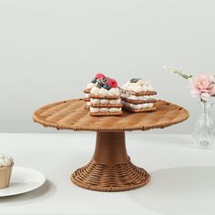 two desserts are sitting on a wicker cake stand