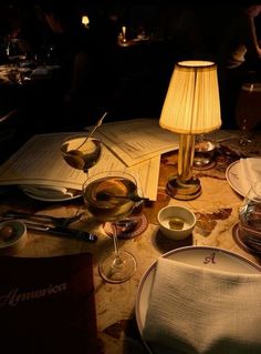 a table topped with plates and bowls next to a lamp