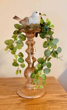 a bird sitting on top of a wooden pole next to a planter filled with leaves