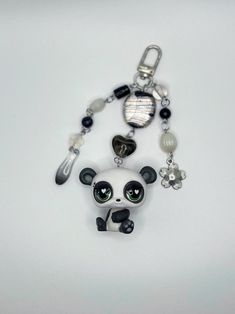 a keychain with a panda bear and other charms on it's side