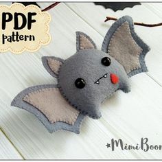 a felt bat hanging on the side of a white wooden wall with bats around it