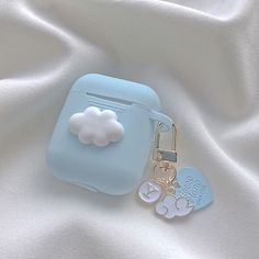 a blue case with a cloud keychain attached to it on a white cloth