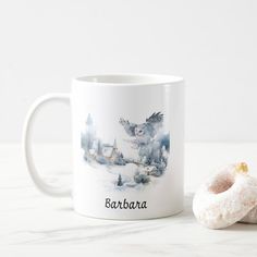 a white coffee mug sitting next to a donut