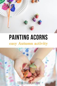 a child's hands holding colorful acorns in front of a paper plate with crayons on it