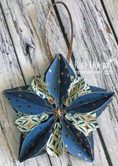 an origami flower hanging from a string on a wooden surface with stars and stripes