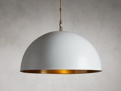 a white and gold light hanging from a ceiling