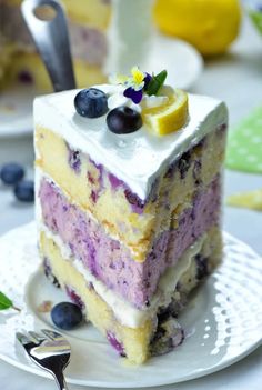 a slice of cake with blueberries and lemon on top