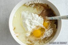 a bowl filled with eggs and cream on top of a table