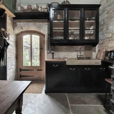 a kitchen with brick walls and black cabinets