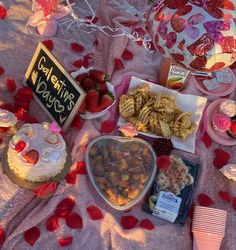 a table topped with lots of food and desserts next to a sign that says valentine's day