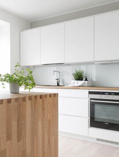 a kitchen with white cabinets and wooden counter tops