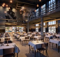 the inside of a restaurant with many tables and chairs set up for people to eat