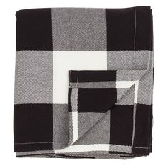 a black and white checkered blanket folded on top of each other with two matching pillows