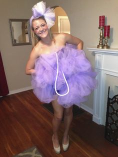 a woman in a purple tutu skirt and headpiece is smiling at the camera