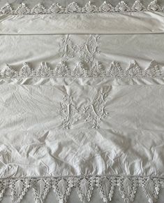 an old white bed spread with lace trimmings on the edges and bottom edge