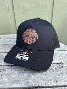 "It's not a Dad Bod It's a Father Figure Hat - what more is there to say? We also make and sell full custom Patch hats. Wooden patches, leather patches, cork patches, etc. Please see our other listings to place a custom order with your logo or another desired graphic! This is a Dad Bod Patch Hat.  Stand out with a high-quality patch adding your business logo or image engraved. We do wood patches, leatherette patches, cork patches, etc.  PRODUCT DETAILS -------------------------- ~ Richardson 112 trucker style snapback hats ~ Add your logo on our high quality custom made hats. ~ Please get in touch with us or view other listings to order bulk orders of 5+ hats!  HOW TO ORDER ----------------------- 1. Select hat color from the drop-down. All colors/styles are shown in a photo in our listing Father's Day Black Hat With Curved Brim, Black Curved Brim Hat For Father's Day, Black Flat Bill Hats For Father's Day, Black Snapback Hat With Curved Brim For Father's Day, Black Baseball Cap With Curved Brim For Father's Day, Father's Day Black Snapback Hat With Curved Brim, Black Hat With Leather Backing And Curved Brim, Black Curved Brim Baseball Cap For Father's Day, Black Trucker Hat For Father's Day With Curved Bill