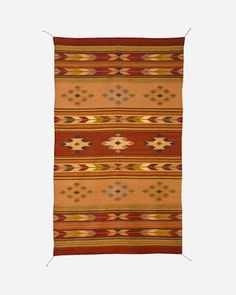 an orange and brown rug with geometric designs on it's sides, against a white background