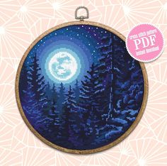 a cross stitch pattern with the moon and trees on it