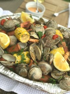 a platter filled with clams and corn on the cob