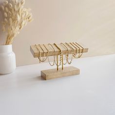 a white vase filled with flowers next to wooden jewelry stands on top of a table