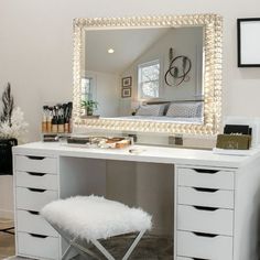 a white vanity with a mirror and stool