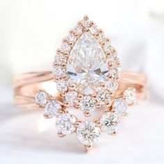 lab diamond ring stack rose gold pear diamond halo engagement ring set La More Design Jewelry Pear Ring Set, Halo Diamond Ring Set, Rose Gold Halo Ring, Pear Cut Diamond Ring, Pear Moissanite Engagement Ring, Diamond Alternative Engagement Ring, Traditional Engagement, Rose Gold Tiara, Lab Created Diamond Rings