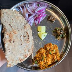 a person holding a plate with food on it and some other items in the bowl