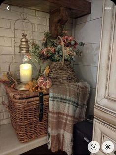 two wicker baskets with flowers and a candle sit on a shelf next to a window