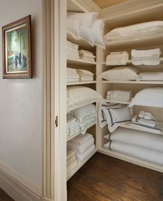 the closet is full of white linens and folded towels