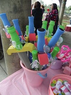 a pink bucket filled with lots of different items on top of a purple table cloth