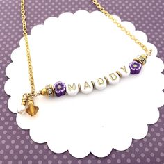 "Beaded Name Necklace for Kids, Birthday Jewelry for Girls, Beaded Bar Necklace, Personalized Gift, Children's Jewelry, Custom Name Jewelry ------------------------ This cute beaded little name necklace makes a special birthday gift for your favorite little girl! Letter beads with a custom name are strung on heavy wire and then attached to a chain with a lobster claw clasp. Purple accent flowers are on either side along with sparkly rhinestone spacers, a Swarovski Crystal birthstone bead, and a Beaded Name Necklace, Necklace For Kids, Accent Flowers, Bead Bar Necklace, Children's Jewelry, Jewelry For Girls, Bead Bar, Bar Necklace Personalized, Special Birthday Gifts