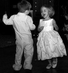 two young children dressed in formal wear dancing on the dance floor at a wedding reception