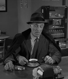 a man sitting at a table with a cup of coffee